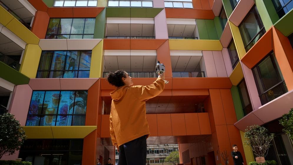 User holding Lixel K2 scanning a colorful building outdoors